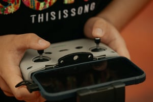 a close up of hands holding a controller