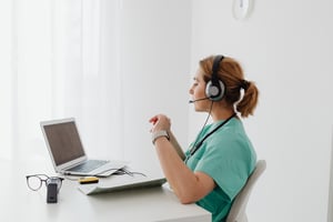 a woman with a headset working on a Laptop