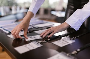 a close up of a persons hands placing name badges on a table