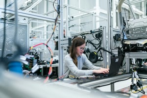 a woman working on a laptop in an electonic workstation